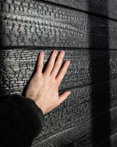 Hände berühren Yakisugi Wand