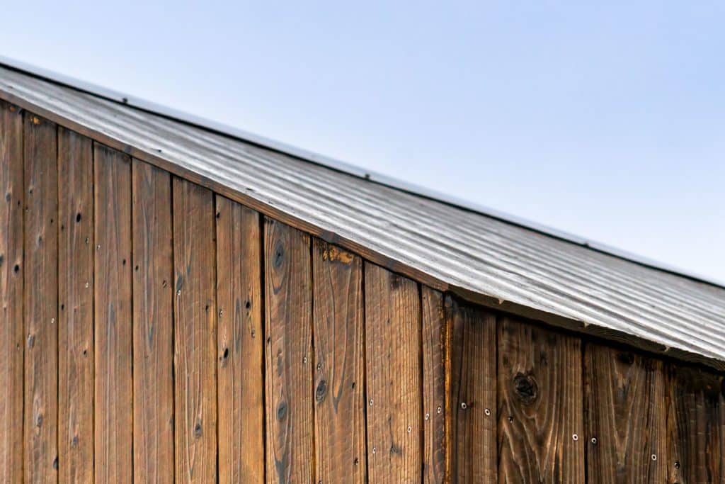 hellbraune Holzfassade mit Spitzdach und blauem Himmel