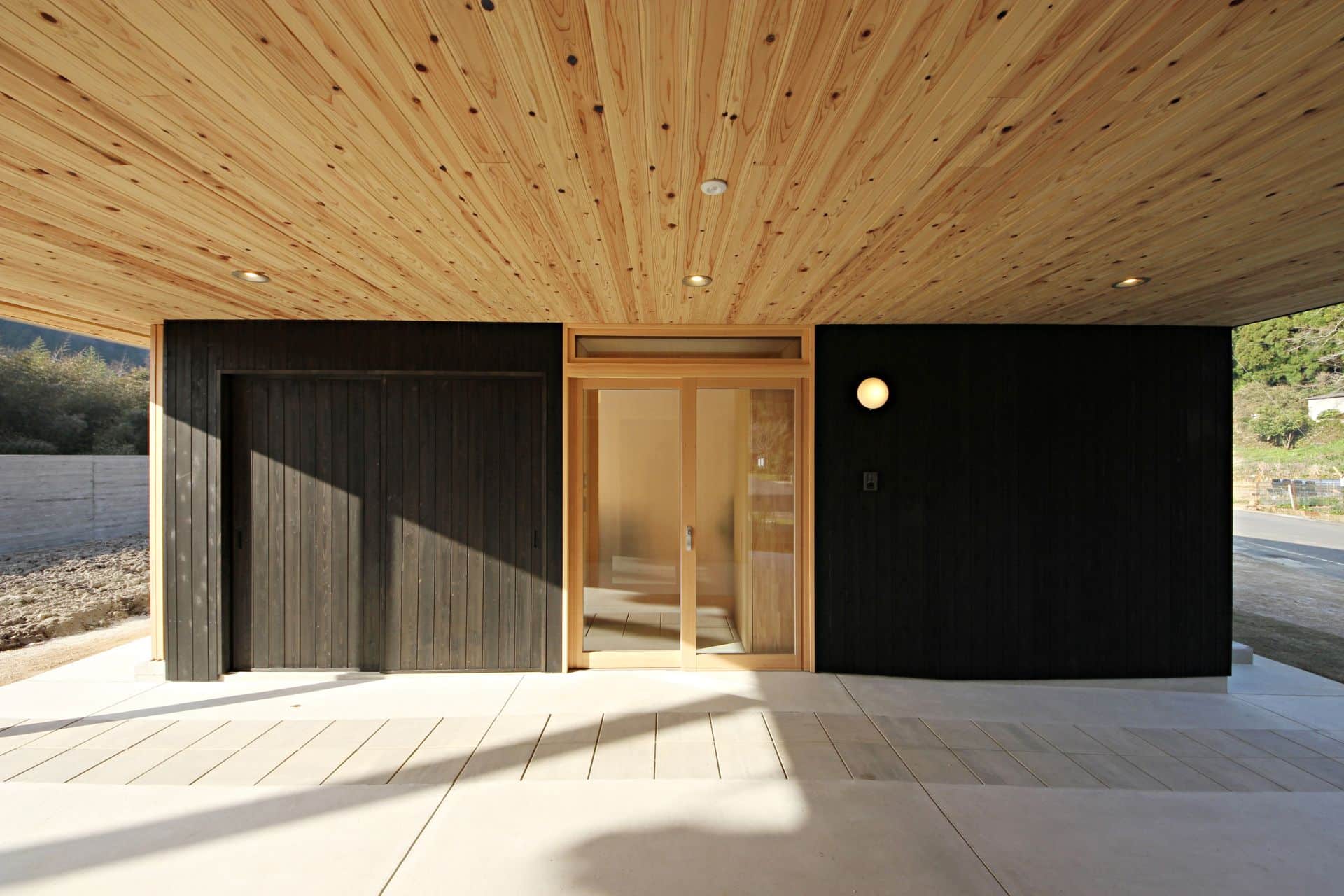 Schwarze Holzwandfassade mit heller Decke aus Sugi Holz