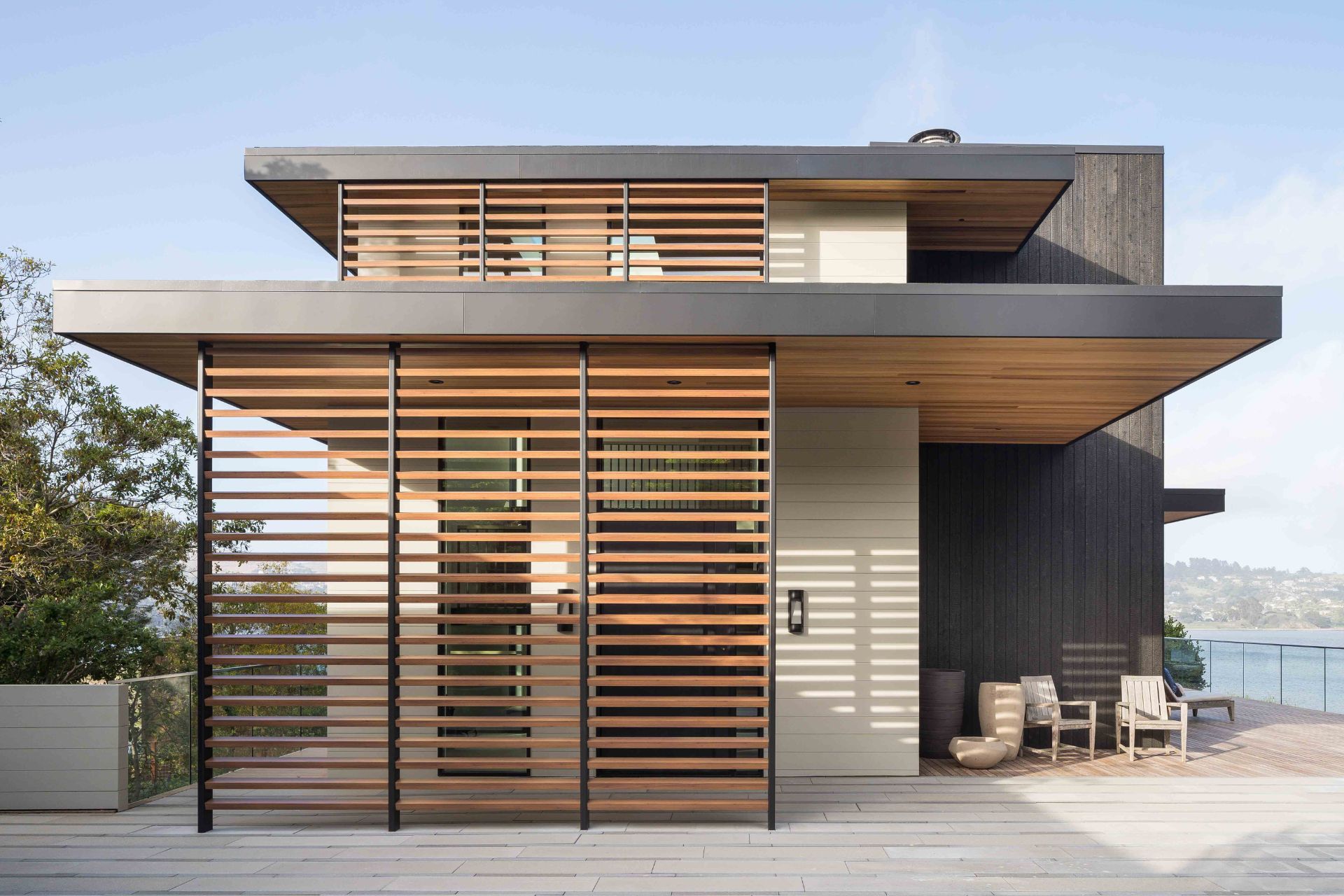 Haus mit heller und dunkler Holzfassade und Sichtschutzelementen
