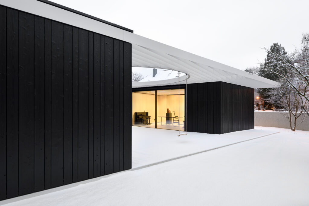 Inner courtyard in winter with lit-up living room